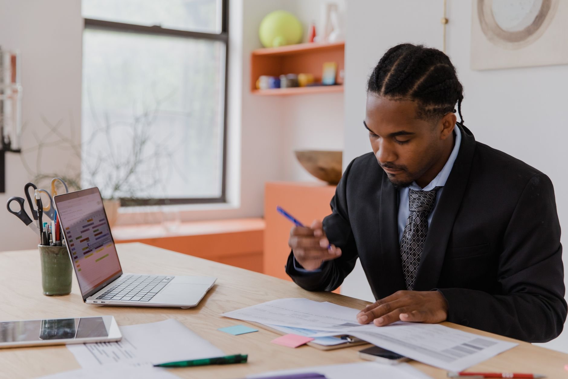 A professional businessman reviewing documents in a modern office environment.